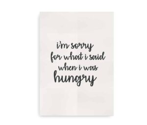Plakat med teksten "I'm sorry for what I said when I was hungry" i sort skrift på en lys baggrund. En humoristisk dekoration til hjemmet.