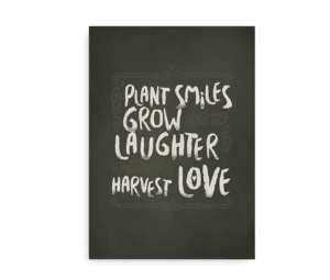 Mørkegrøn plakat med teksten "Plant smiles, grow laughter, harvest love" i håndskrevet stil omgivet af dekorative detaljer.