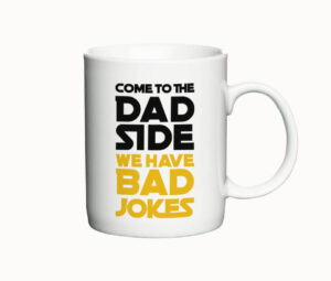 Hvidt keramikkrus med teksten "Come to the Dad Side, we have Bad Jokes" i sort og gul skrift.