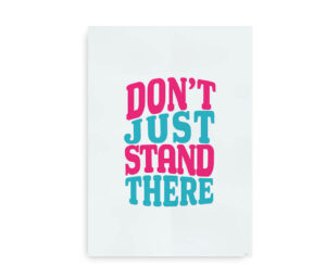 Motiverende plakat med teksten "Don't Just Stand There" i en farverig typografi med lyserøde og blå nuancer.