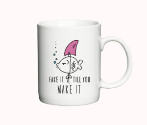 Hvidt kaffekrus med illustration af en fisk med en falsk hajfinne og teksten "Fake it till you make it".