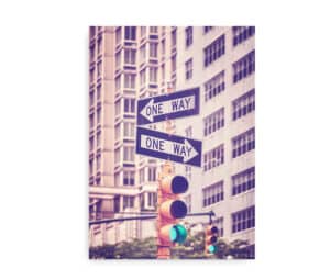 Plakat af New Yorks "One Way"-skilte og et trafiklys, omkranset af høje bygninger med et vintage-filter.