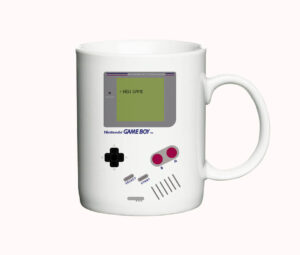 Hvidt keramisk krus med en retro Nintendo Game Boy illustration og teksten "NEW GAME" på skærmen.