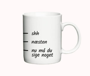 Hvid kaffekop med humoristisk tekst og en skala, der går fra "shh" til "nu må du sige noget". Sjov og kreativ kop til morgenkaffen.