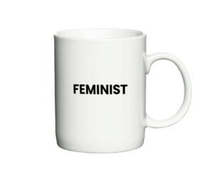 Hvid kaffekop med teksten "Feminist" skrevet i sort, enkel skrifttype.
