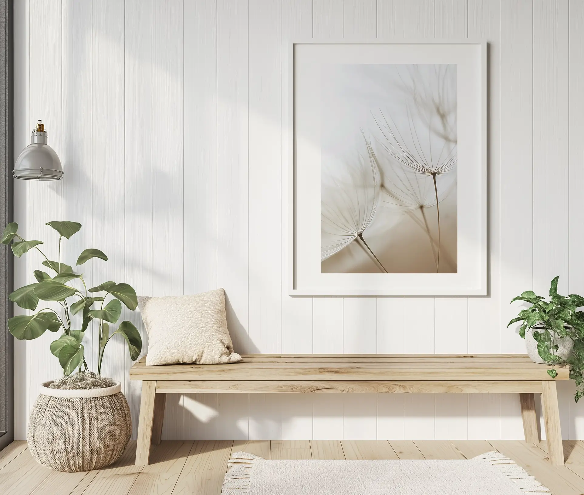 Plakat med sarte mælkebøttefrø hængende i et lyst, minimalistisk rum med træbænk og grønne planter.