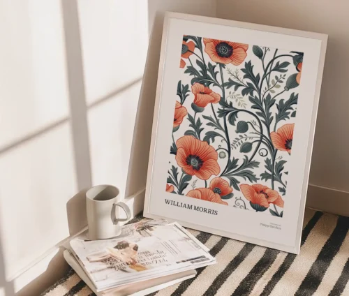 William Morris inspireret "Poppy Garden" plakat med røde valmuer og grønt løv, placeret på gulvet ved siden af magasiner og en kop.