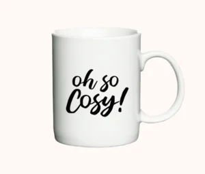 Hvidt krus med teksten "Oh So Cosy!" i enkel sort skrift, ideelt som julekrus.