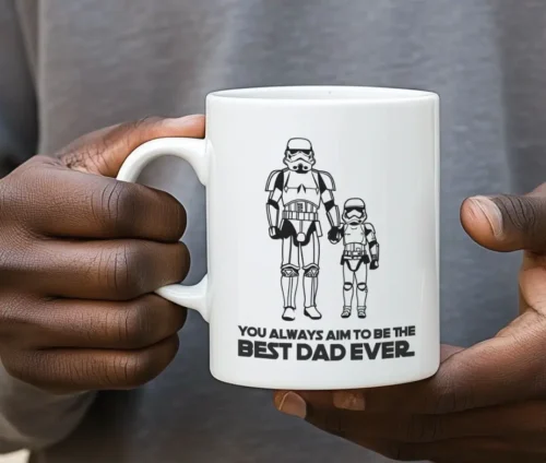 Person holder hvidt krus med sort-hvidt design og teksten "Best Dad Ever".