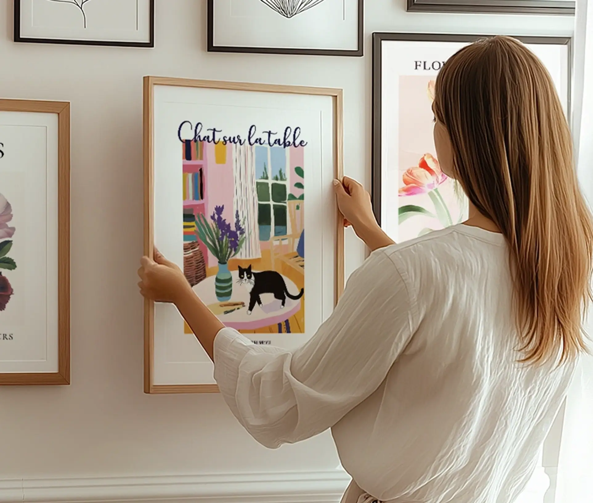 Kunstplakat med en sort-hvid kat på et bord i et farverigt interiør.