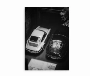 Sort-hvid plakat med to klassiske Porsche-biler parkeret side om side.