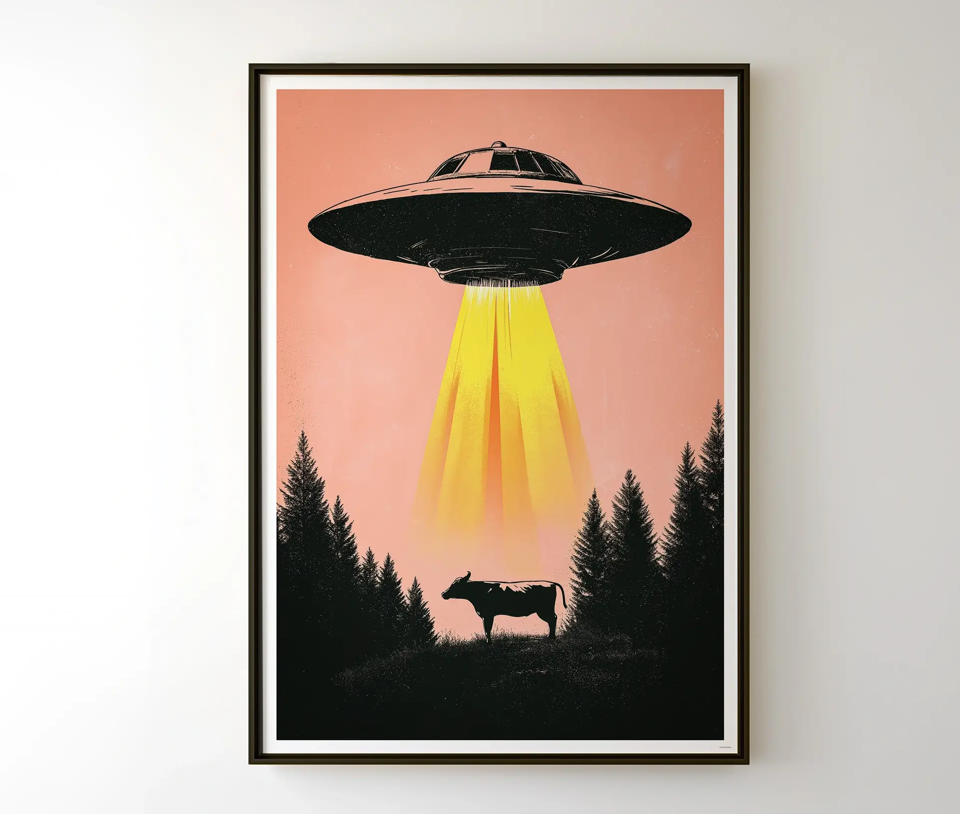 Indrammet UFO plakat hængende på en væg, der viser et sci-fi motiv med en flyvende tallerken og en ko.