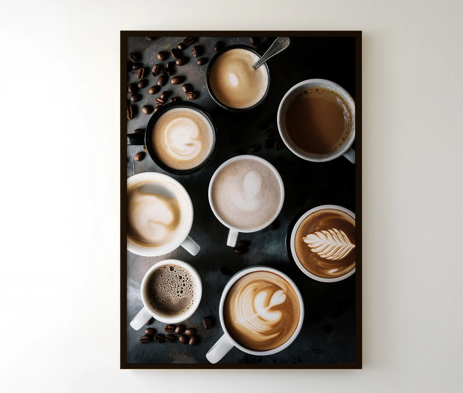 Indrammet kaffeplakat med forskellige kaffekopper og latte art, ophængt på en hvid væg.