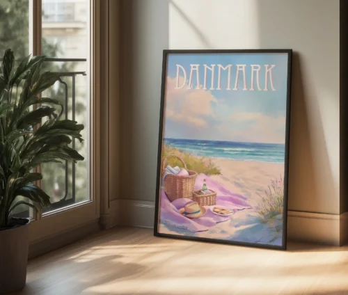 Plakat med strandmotiv lænet op ad en væg i et lyst rum med sollys.