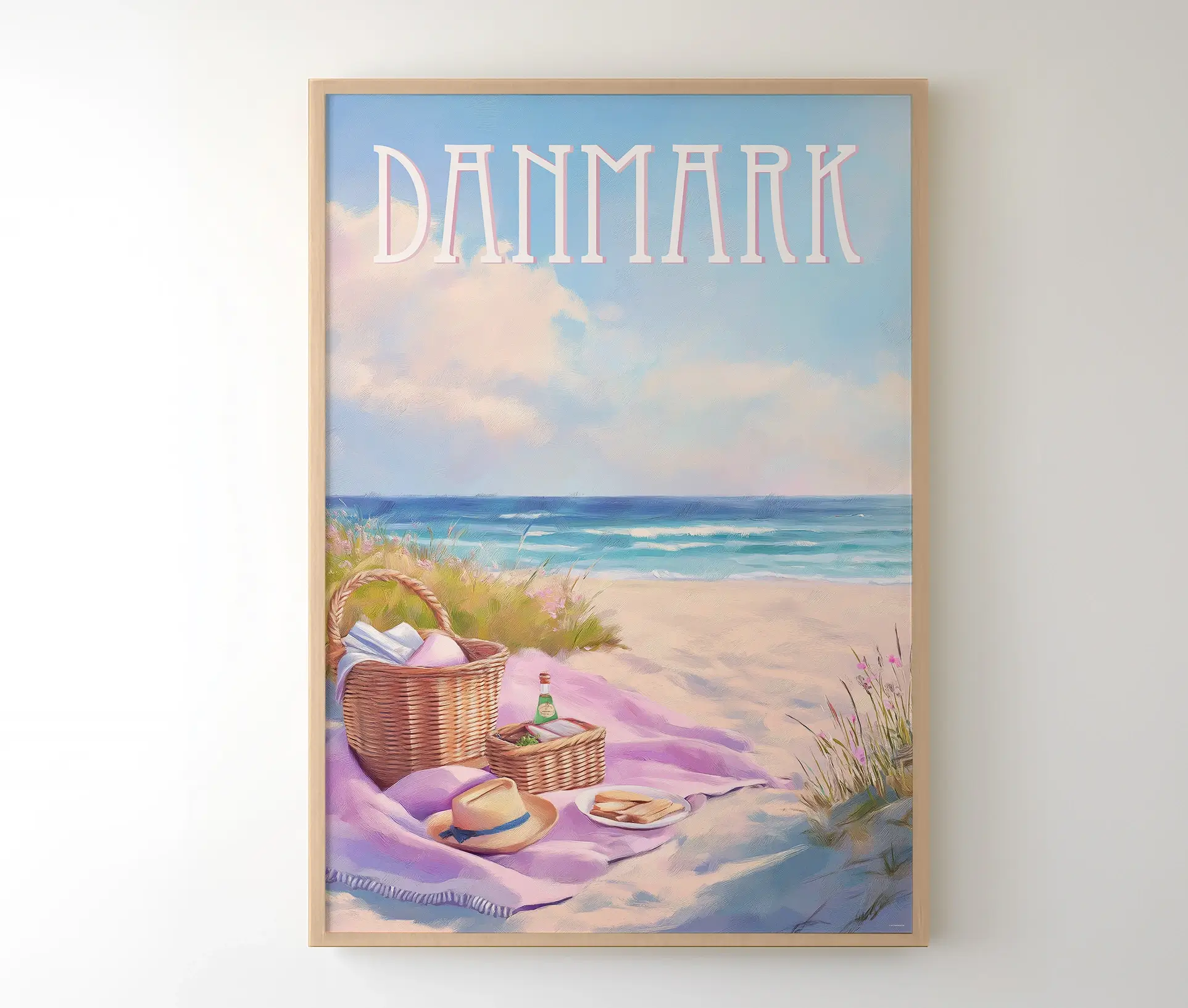 Plakat med dansk strandmotiv indrammet i lys træramme, hængende på en væg.