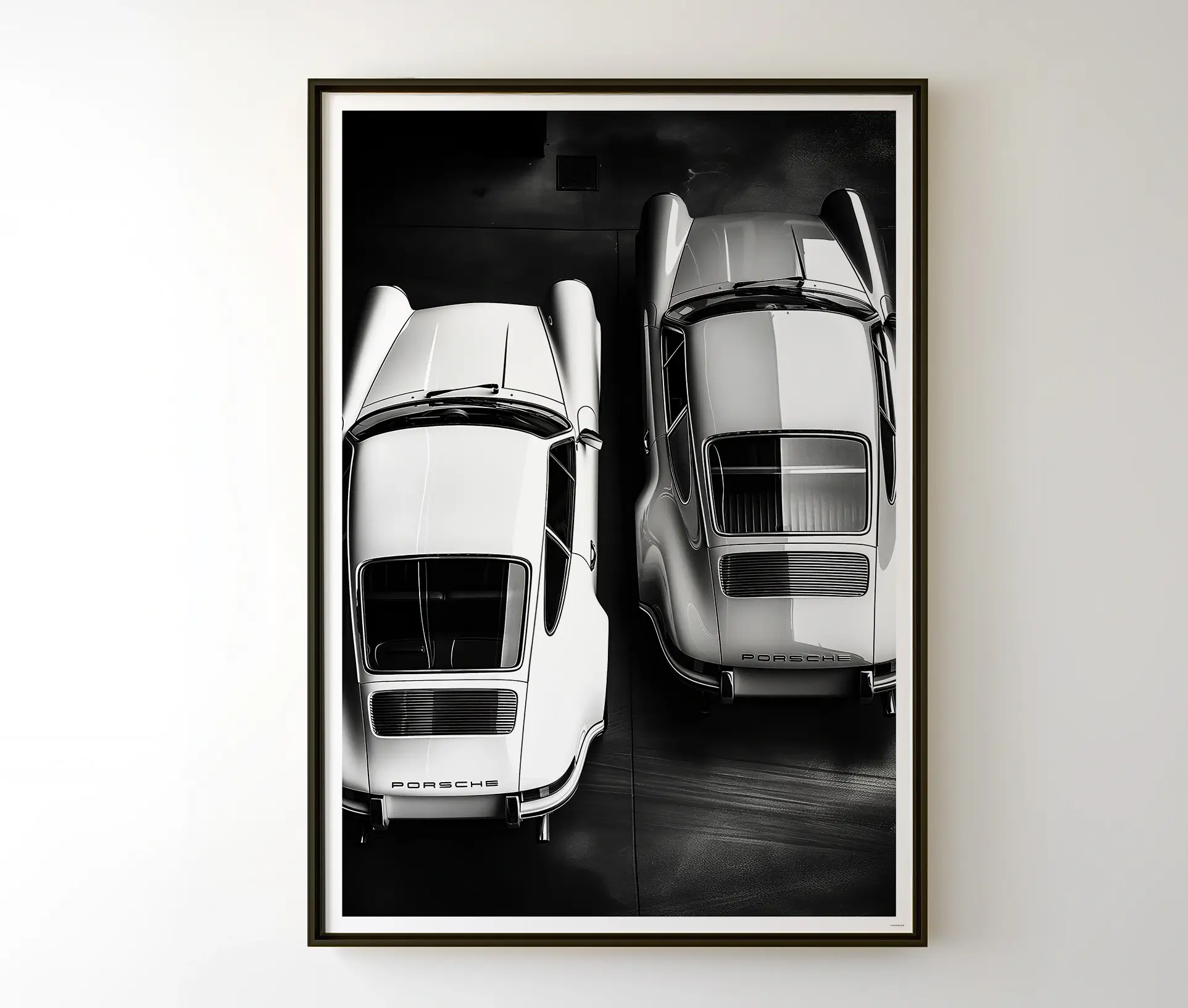 Indrammet Porsche plakat i sort-hvid, hængende på en væg.