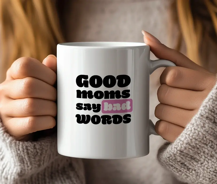 Hvidt kaffekrus med teksten Good Moms Say Bad Words trykt i sort med lyserød detalje.