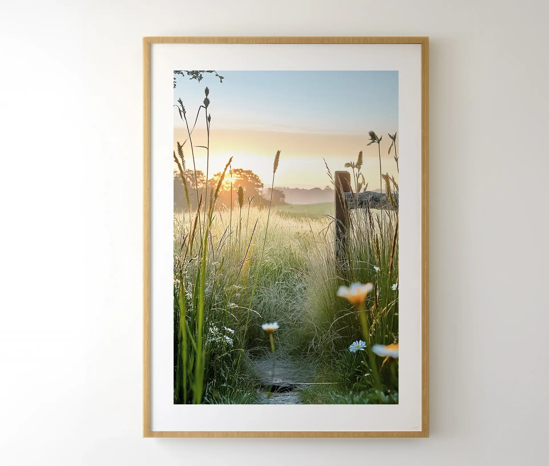 Indrammet plakat med en solopgang over en grøn eng, omgivet af vild natur.