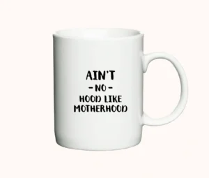 Hvidt keramikkrus med teksten Ain’t No Hood Like Motherhood i sort.