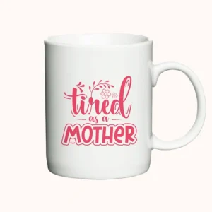Keramikkrus med teksten "Tired as a Mother", lyserød skrift på hvid baggrund.