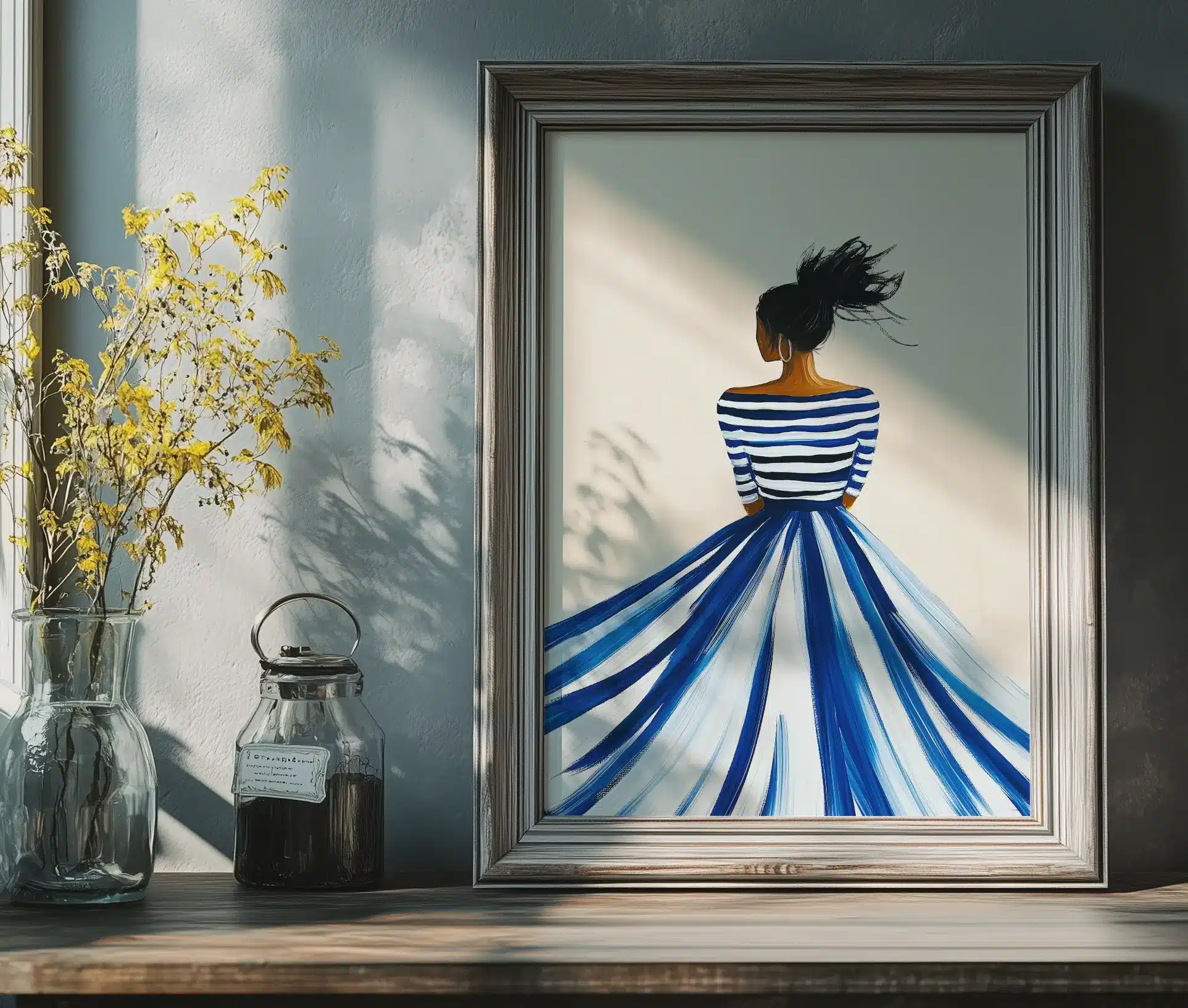 Indrammet plakat med kvinde i blåstribet kjole placeret på kommode