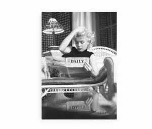 Sort-hvid plakat med Marilyn Monroe der læser avis i sofa