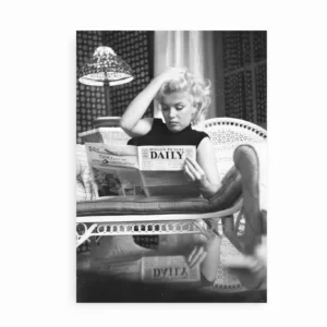 Sort-hvid plakat med Marilyn Monroe der læser avis i sofa