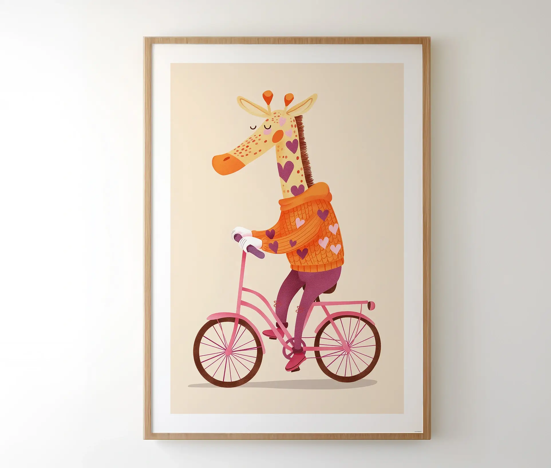 Plakat med giraf på cykel i ramme hængt op på væg.