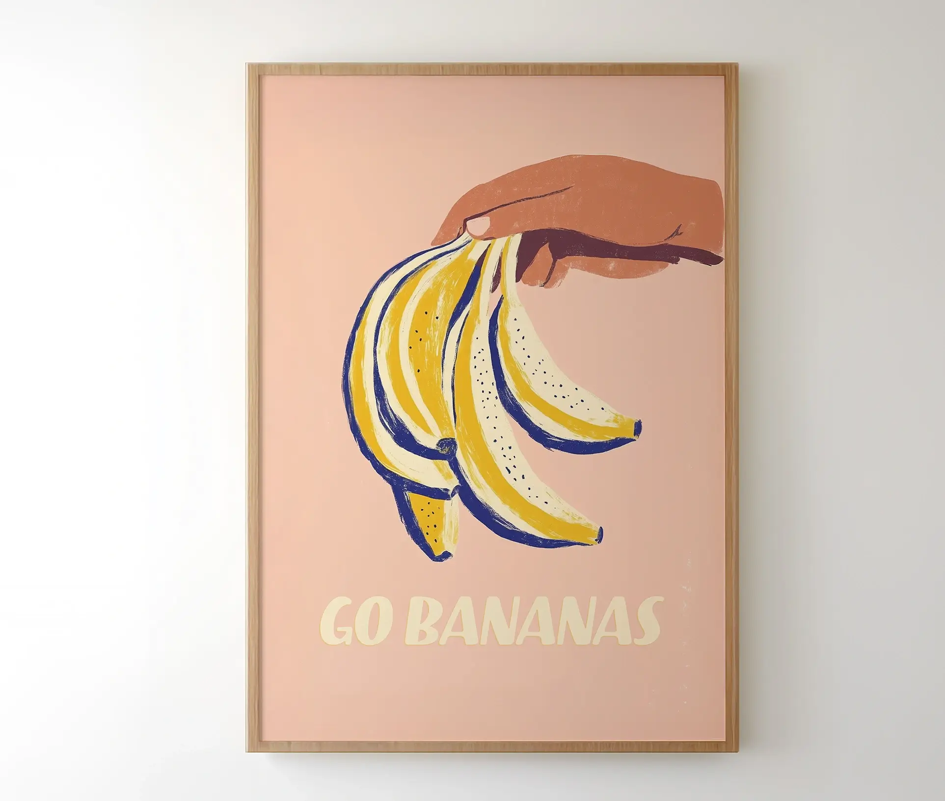 Plakat med hånd og bananer monteret i ramme på væg.