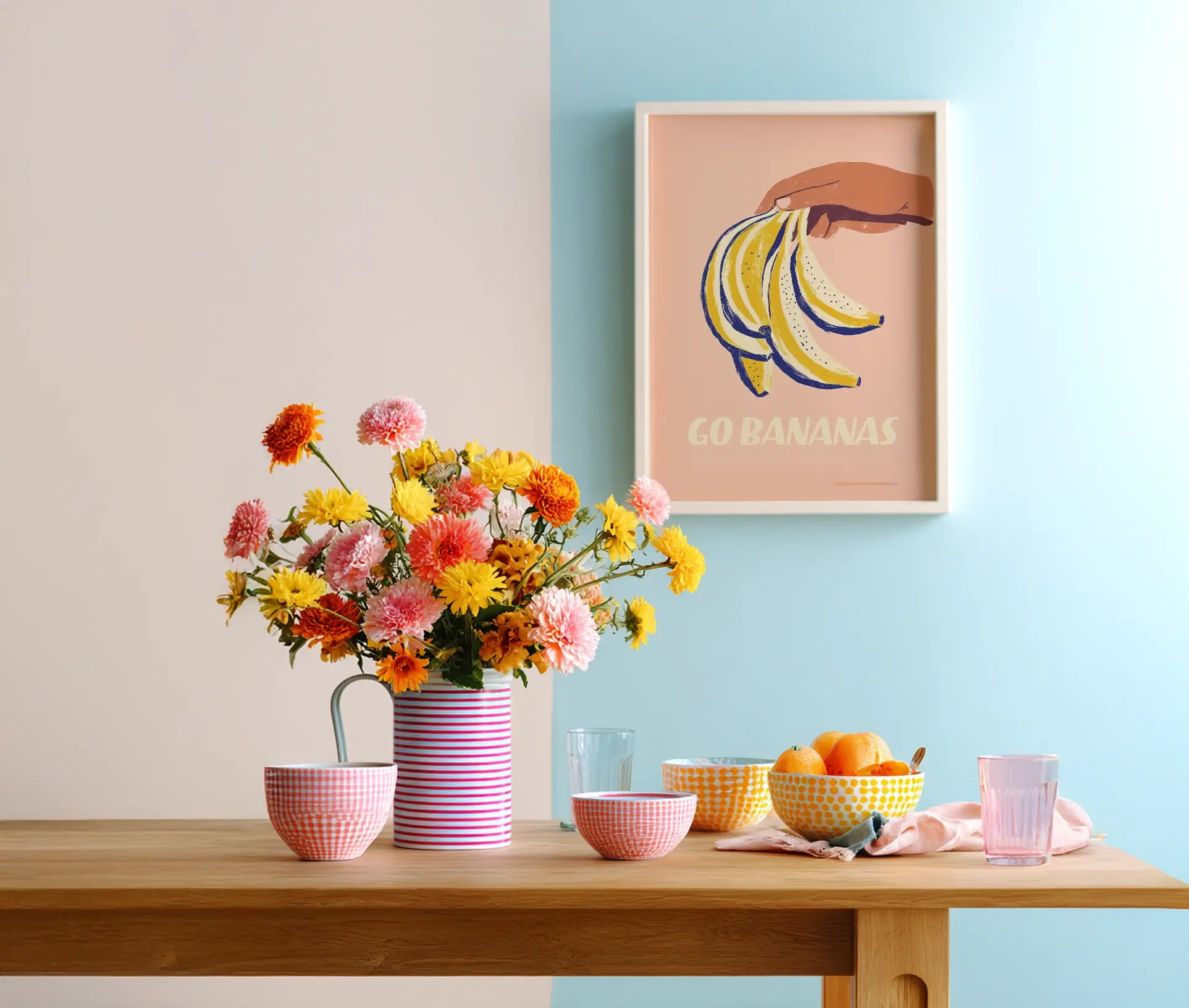 Plakat med hånd og bananer hængende over farverig morgenbordopstilling.