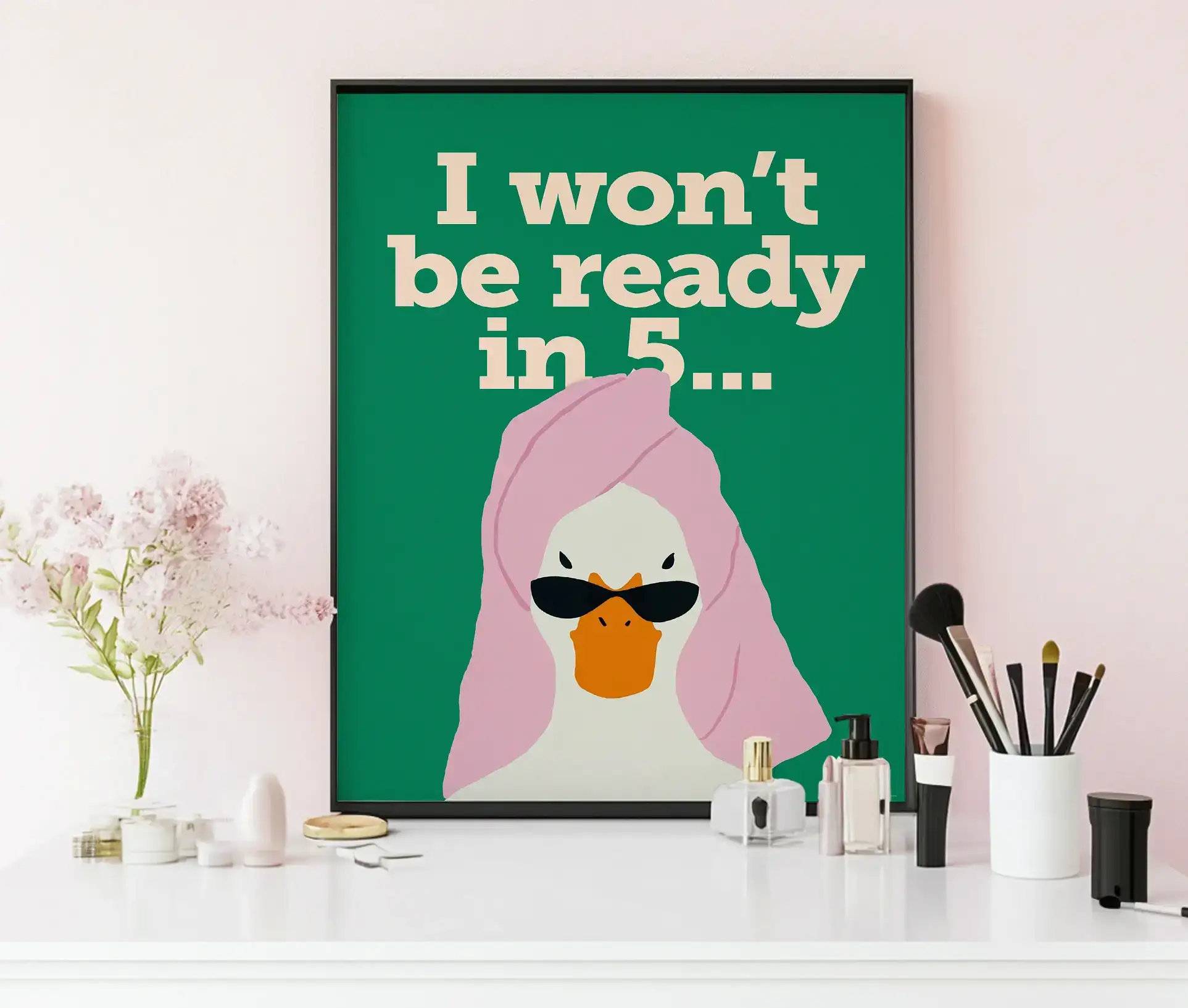 Plakat med and og tekst placeret på sminkebord