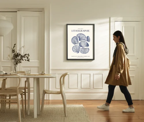 Plakat med fransk tekst og blå grafisk illustration hængende på væg