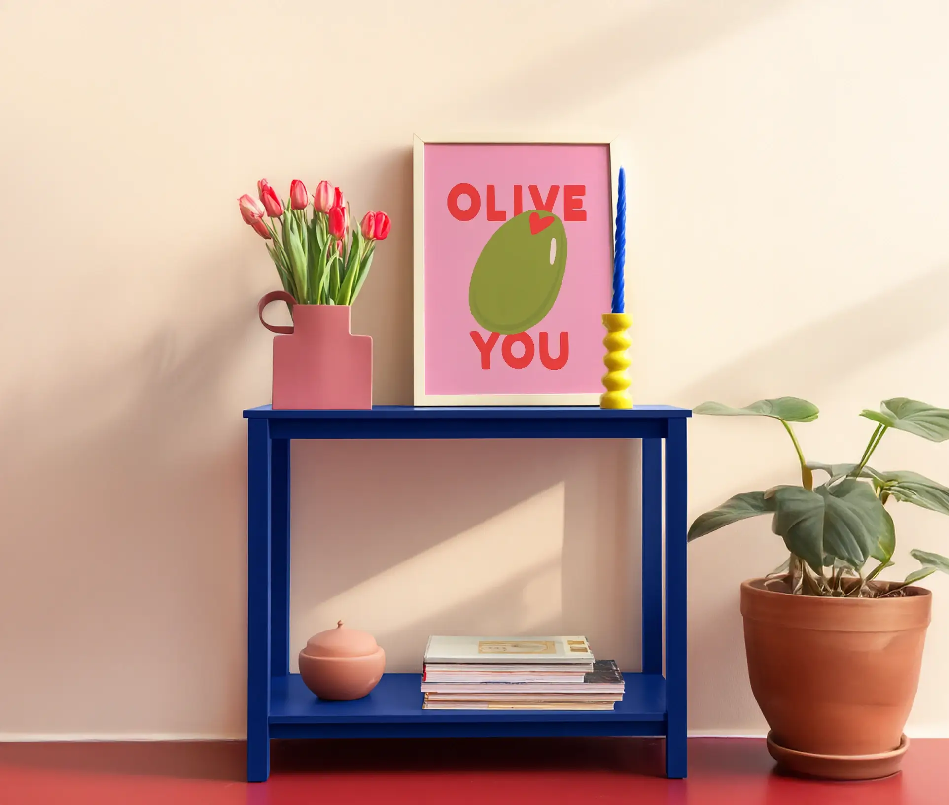 Plakat med teksten Olive You og grøn oliven på lyserød baggrund i ramme