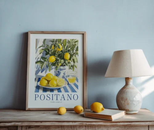 Plakat med citroner og Positano-tekst på kommode med bøger og bordlampe