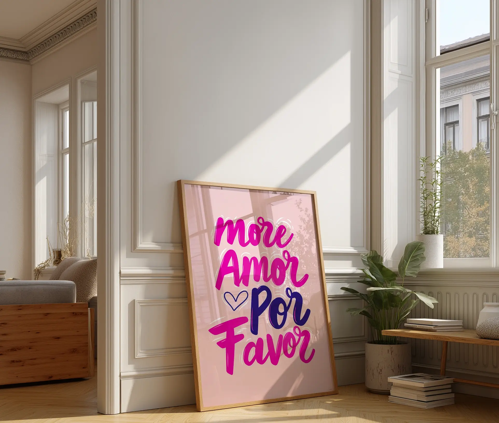 Plakat med teksten "More Amor Por Favor" i pink og lilla farver, placeret på gulv ved vindue