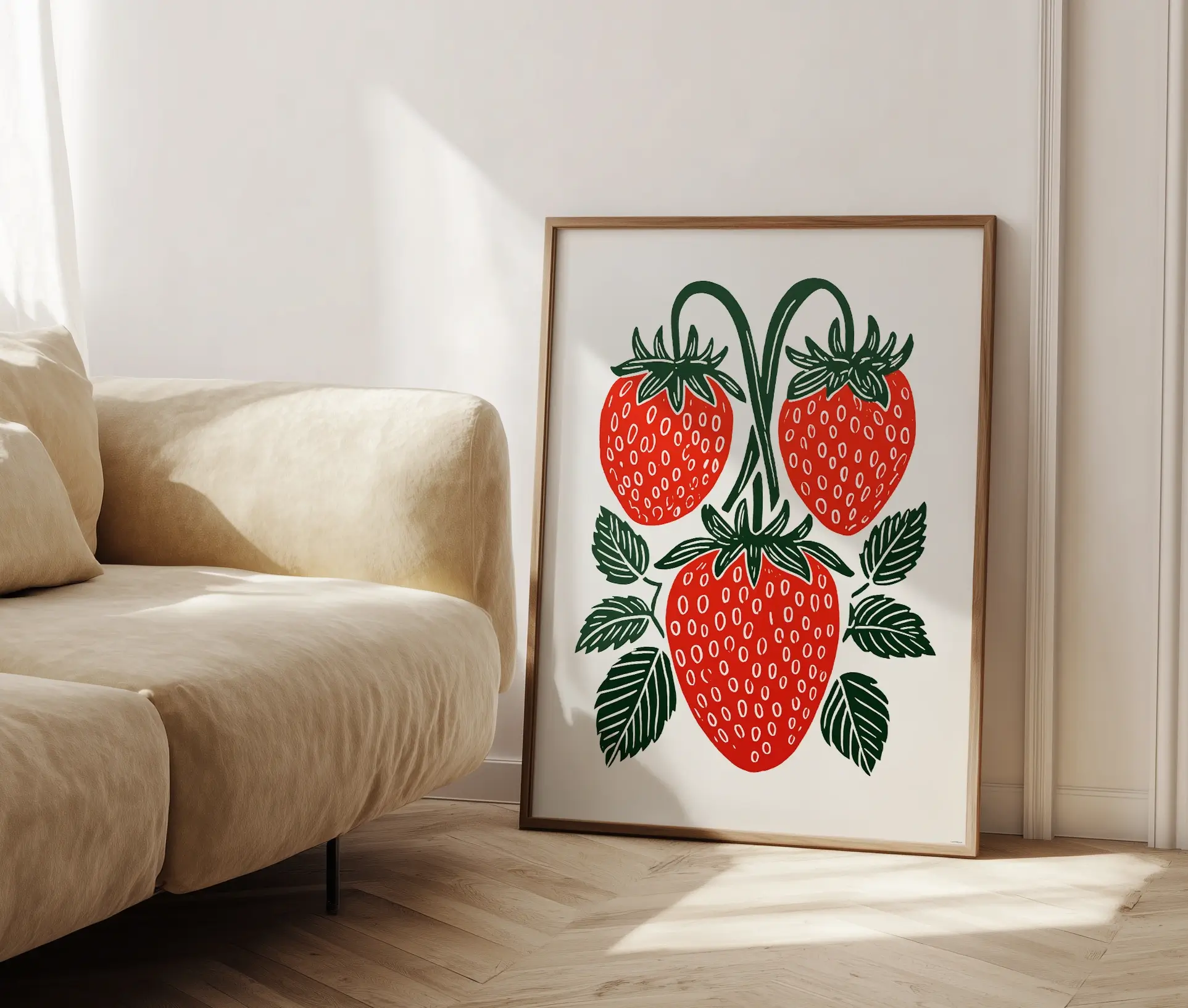 Plakat med jordbær placeret i ramme ved sofa