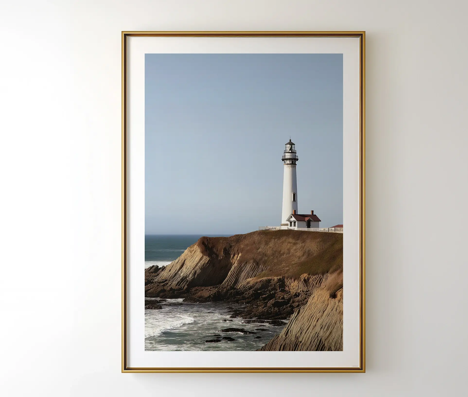 Fyrtårnsplakat med klipper og havudsigt, hængende på væg.