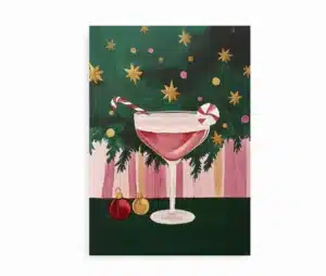 Farverig juleplakat med cocktailglas pyntet med candy cane foran juletræ.
