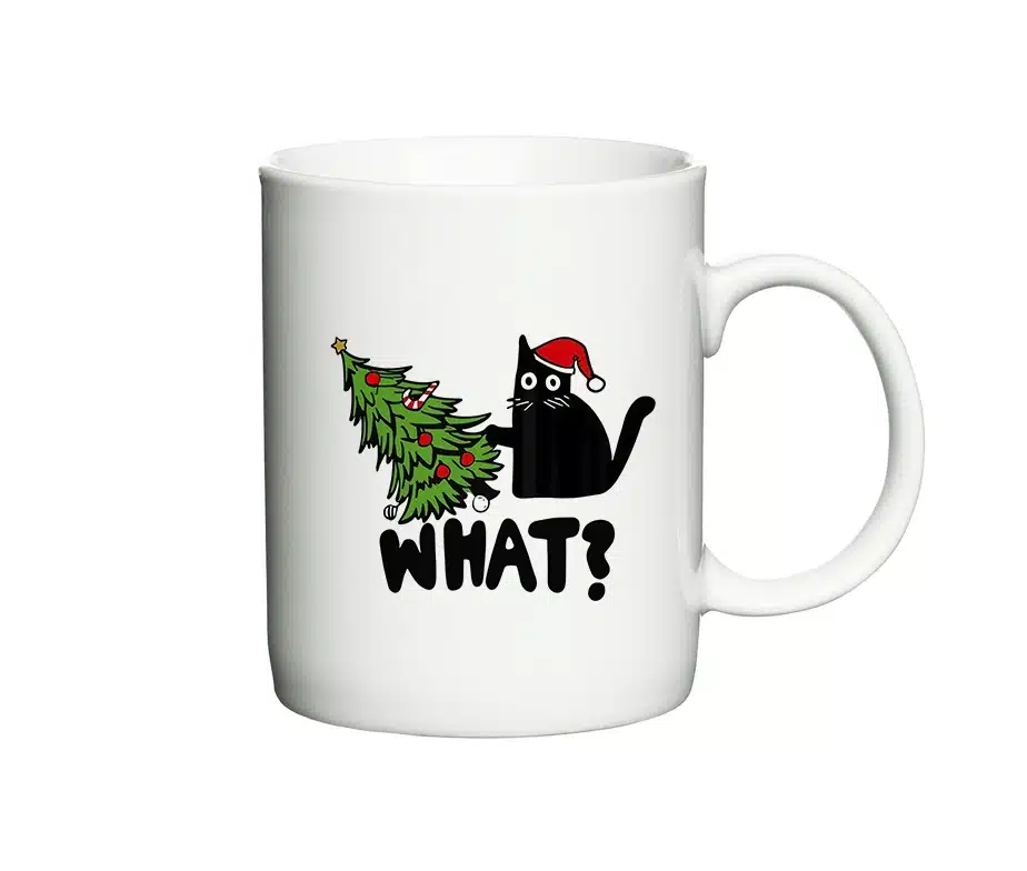 Hvid kaffekop med motiv af sort kat med nissehue, væltet juletræ og teksten “WHAT?”.