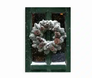 Plakat med grøn dør og julekrans med kogler dækket af sne. Snefnug falder udenfor.