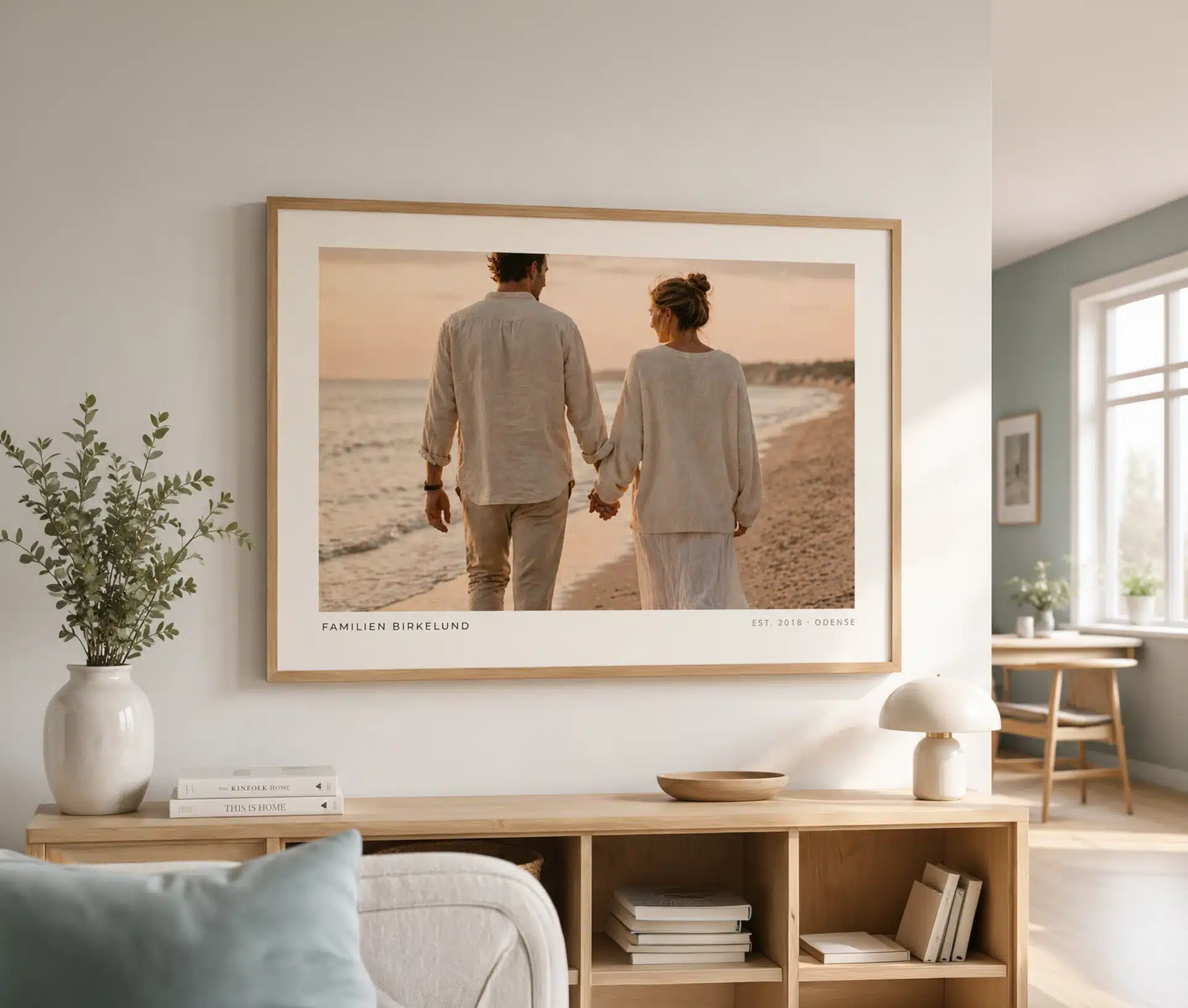 Familieplakat ophængt i moderne skandinavisk stue over træreol