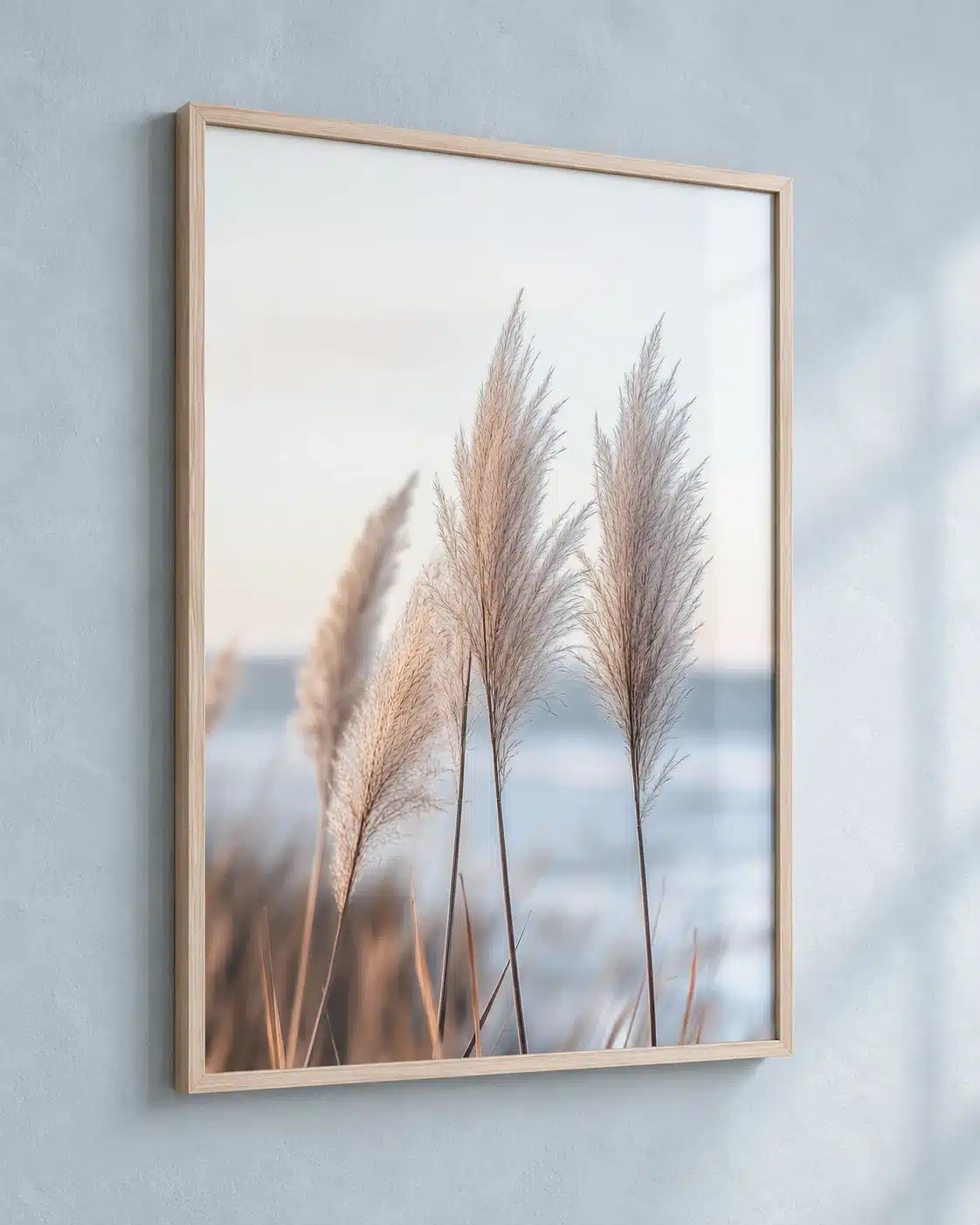Indrammet plakat med lyst pampasgræs og roligt strandmotiv